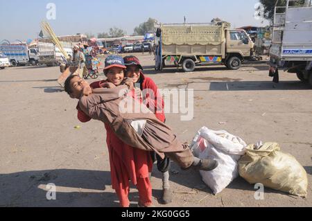 Ismalabad, Pakistan. 20.. November 2022. Afghanische Flüchtlingsjungen arbeiten auf einem Gemüsemarkt, um ihren Familien in Islamabad ihren Lebensunterhalt zu verdienen. Die in ihrer Freizeit gerne spielen. Tausende von Kindern arbeiten in Pakistan in Kinderarbeit. Beamte und Vertreter der pakistanischen Regierung sagten anlässlich des Internationalen Kindertages, dass die Regierung den Rechten der Kinder Vorrang einräumt. (Bild: © Raja Imran/Pacific Press via ZUMA Press Wire) Stockfoto