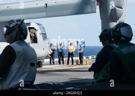 221020-N-XN177-1136 OSTCHINESISCHES MEER (OKT 20, 2022) – Matrosen entfernen Unterlegkeile und Ketten aus einem MV-22 Tiltrotor-Flugzeug von Osprey, das Marine Medium Tiltrotor Squadron (VMM) 262 (verstärkt) auf dem Flugdeck an Bord des amphibischen Angriffsträgers USS Tripoli (LHA 7) am 20. Oktober 2022 zugewiesen wurde. Tripolis ist im Einsatzgebiet der US-Flotte von 7. tätig, um die Interoperabilität mit Verbündeten und Partnern zu verbessern und als einsatzbereite Einsatztruppe für den Frieden und die Stabilität in der Region Indo-Pazifik zu dienen. Stockfoto