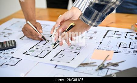 Nahaufnahme und zugeschnittenes Bild, Team oder professionelle Bauingenieure oder Architekten diskutieren und betrachten die Blaupause zusammen. Stockfoto