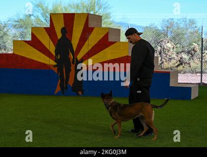 US Air Force Staff Sgt. Travis Bell, 355. Security Forces Squadron Military Working Dog Handler, spaziert während einer MWD-Demonstration auf der Davis-Monthan Air Force Base, Arizona, am 19. Oktober 2022 an der Seite von Ssilke, 355. SFS MWD. Jeder MWD, der beim „Puppy Program“ auf dem Luftwaffenstützpunkt Lackland, Texas, trainiert, hat einen doppelten Anfangsbuchstaben in seinem Namen. Das Programm ermöglicht qualifizierten Freiwilligen, Welpen zu pflegen und ihnen Lern- und Spielmöglichkeiten zu bieten. Stockfoto