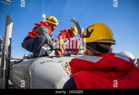 OSTSEE (Okt 19, 2022) Boatswains Mate 3. Klasse Jaylon Lewis, links, und Boatswains Mate 2. Klasse Omaro Luke, Mitte, bereiten während des Bootbetriebs am 19. Oktober 2022 ein Rigid-Hull-Schlauchboot (RHIB) an Bord des Arleigh Burke-Klasse-Lenkflugkörper-Zerstörers USS Roosevelt (DDG 80) vor. Roosevelt befindet sich im geplanten Einsatzgebiet der US Naval Forces Europe, das von der Sechsten Flotte der USA eingesetzt wird, um die Interessen der USA, der Alliierten und der Partner zu verteidigen. Stockfoto