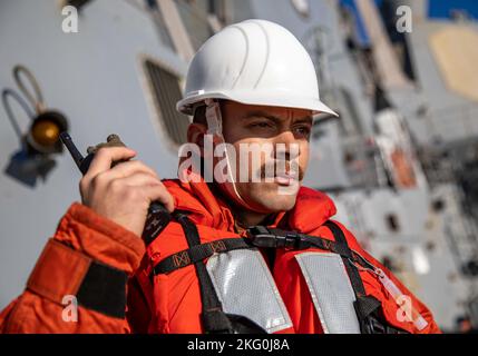 OSTSEE (Okt 19, 2022) LT. j.g. Adam Brandt hört während des Schiffsbetriebs an Bord des Arleigh Burke-Klasse-Lenkraketen-Zerstörers USS Roosevelt (DDG 80) ein Radio, 19. Oktober 2022. Roosevelt befindet sich im geplanten Einsatzgebiet der US Naval Forces Europe, das von der Sechsten Flotte der USA eingesetzt wird, um die Interessen der USA, der Alliierten und der Partner zu verteidigen. Stockfoto