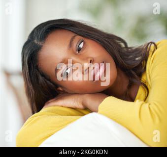 Tief in Gedanken. Eine attraktive junge Frau, die zu Hause nachdenklich aussieht. Stockfoto
