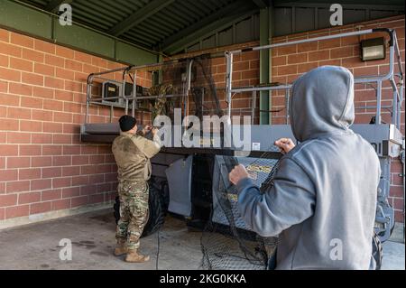 U.S. Air Force Master Sgt. Sterling Hall, Senior Master Sgt. Nate Smith, Lademeister, beauftragt mit dem Sicherheitsbüro des Luftlift Wing 167., und Chad Neil, ein Biologe beim Tier- und Pflanzenschutzinspektionsdienst der USDA, bereiten Vogelnetze für die Installation in einem Gebäude für Flüssigsauerstoffspeicher in Shepherd Field, Martinsburg, West Virginia, vor, 19. Oktober 2022. Vögel können Gefahren für den Flugverkehr darstellen und ihre Kot kann zu Sicherheits- und Sanitärproblemen führen. Stockfoto