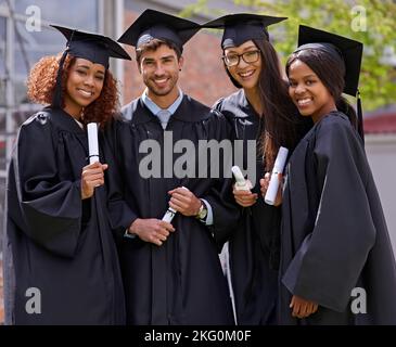 Wir bauen unsere Zukunft auf harter Arbeit. Lächelnde Studenten am Abschlusstag. Stockfoto