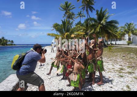 Gruppe französisch-polynesischer Kinder in traditioneller Kleidung, die einen Fotografen anfeuern Stockfoto
