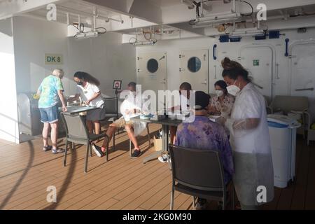 Kreuzfahrtpassagiere, die obligatorischen Covid-Tests an Bord der Aranui vor der Ankunft auf Pitcairn Island unterzogen werden Stockfoto