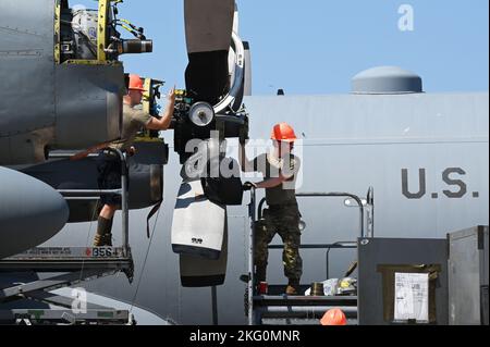 Personal Sgt. Nichola Zamsky und Tech. Sgt. Dan Doyle, Antriebstechniker der Expeditionary Airlift Squadron 75., arbeitet mit ihrem Kranführer zusammen, um eine Ersatzstütze auf einer C-130H in Camp Lemonnier, Dschibuti, zu montieren, 20. Oktober 2022. Durch den Austausch dieser Requisiten kann das Geschwader seine Mission fortsetzen, die richtigen Effekte am richtigen Ort und zur richtigen Zeit zu erzeugen, sowohl in umkämpften als auch in strengen Umgebungen. Stockfoto