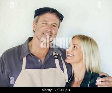 Partner in Wirtschaft und Leben. Ein Bauer und seine Frau stehen vor einer Mauer. Stockfoto