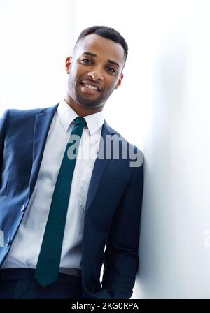 Professionalität definiert ihn. Ein hübscher junger afroamerikanischer Geschäftsmann, der im Haus steht. Stockfoto