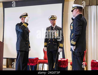 Capt. Brian Hogan, commodore, Submarine Squadron Eight, Mitte, sieht als Cmdr. Christopher Holland, rechts, entlastet Cmdr. Jonathan Cantor, links, als Kommandant des Los Angeles-Klasse-Angriffs-U-Bootes USS Boise (SSN 764) während einer Befehlswechselzeremonie an Bord der Naval Station Norfolk, 21. Oktober 2022. Stockfoto