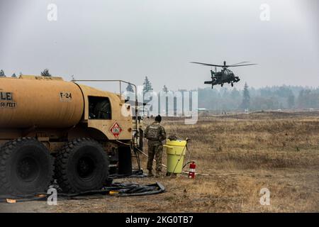Soldaten, die 1-229 Angriffsbataillon, 16. Combat Aviation Brigade zugeordnet sind, tanken, rüsten auf und reparieren AH-64E Apache-Angriffshubschrauber und andere Fahrzeuge am Vorwärts-Bewaffnungs- und Betankungspunkt auf der Joint Base Lewis-McChord, Washington, 20. Oktober 2022. Stockfoto