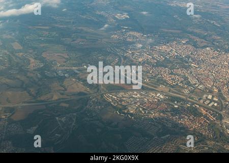 Stadtbild aus einem Flugzeugfenster mit landwirtschaftlichen Feldern in der Umgebung Stockfoto
