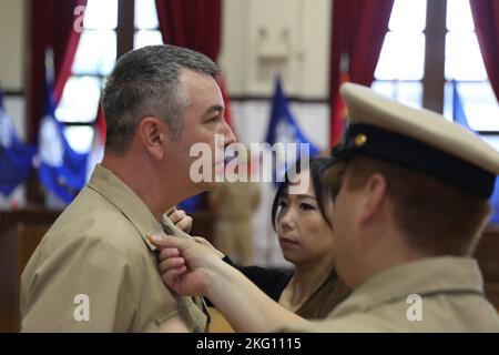 YOKOSUKA, Japan (Okt 21, 2022) Chief Yeoman Jeremy Winteregg wird von seiner Frau und seinem Sponsor während der Pinning Ceremony FY23 des Chief Petty Officers (CPO) für den Kommandanten, die Submarine Group 7, das Verteidigungsdienstbüro Pacific und den Kommandanten der Naval Forces Japan (CNFJ) im CNFJ Auditorium an Bord von Fleet Activities festgehalten Yokosuka, 21. Oktober 2022. Sieben ausgewählte Chief Petty Officer wurden während der Zeremonie zum Chief Petty Officer befördert. Jeder Sailor hatte seine Anker festgesteckt und die CPO-Abdeckungen zum ersten Mal vor seinen Kollegen CPOs, der Befehlsführung, der Familie und Freunden aufgesetzt. Stockfoto