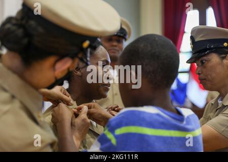 YOKOSUKA, Japan (Okt 21, 2022) die Cheflegerin Ayanna Higgins wird von ihrer Familie und ihren Kollegen während der Pinning Ceremony der Chief Petty Officer (CPO) FY23 für den Kommandanten, die Submarine Group 7, das Verteidigungsdienstbüro Pacific und den Kommandanten der Naval Forces Japan (CNFJ) im CNFJ-Auditorium an Bord von Fleet Activities festgehalten Yokosuka, 21. Oktober 2022. Sieben ausgewählte Chief Petty Officer wurden während der Zeremonie zum Chief Petty Officer befördert. Jeder Sailor hatte seine Anker festgesteckt und die CPO-Abdeckungen zum ersten Mal vor seinen Kollegen CPOs, der Befehlsführung, der Familie und Freunden aufgesetzt Stockfoto