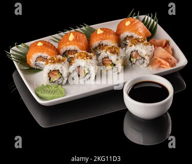Nigiri- und Sushi-Brötchen mit Sojasauce auf schwarzem Hintergrund Stockfoto