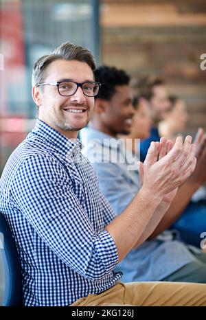 Inspiriert zu Spitzenleistungen. Porträt eines hübschen, reifen Profis, der in einem modernen Konferenzraum eine Präsentation applaudiert. Stockfoto