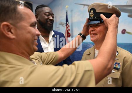 JACKSONVILLE, Florida (Okt. 21, 2022) - Chief Navy Counselor Abbie Talley dons ihre Chief Petty Officer Abdeckung während einer CPO Pinning Zeremonie im Naval Air Station Jacksonville, 21. Oktober 2022. Navy Region Southeast ist die größte Küstenverwaltungsregion innerhalb der US Navy und bietet Unterstützung für 18 Anlagen im Südosten der Vereinigten Staaten. Stockfoto