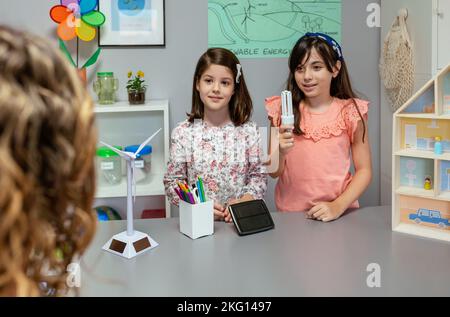 Schüler zeigen LED Lampe zu Lehrerin in Ökologie Klassenzimmer Stockfoto