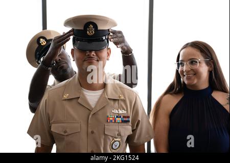 ST. LOUIS (Okt 21, 2022) der Chief Gas Turbine Systems Technician (Electrical) Marcus Jones, der der Navy Talent Acquisition Group (NTAG) Mid America zugewiesen wurde, hat während einer CPO-Pinning-Zeremonie am 21. Oktober 2022 von seinem Vater, Chief Petty Officer (CPO), eine Kombinationsabdeckung auf seinen Kopf gelegt. NTAG Mid America, Teil des Navy Recruiting Command, rekrutiert die nächste Generation von Navy-Seeleuten in Gebieten, die Missouri, Kansas, Zentral- und SüdIllinois und einen Teil von Kentucky umfassen. Stockfoto