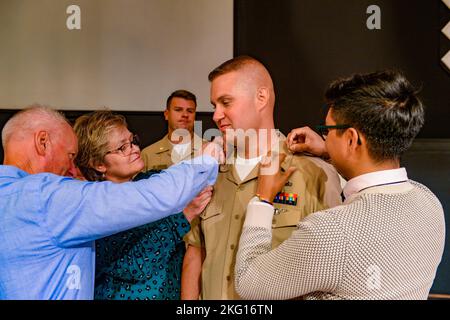 Tyler Waddell, Chief Operations Specialist der US-Marine aus Center City, Minnesota, der dem Flugzeugträger USS John C. Stennis (CVN 74) zugewiesen wurde, hat seinen neuen Rang während einer Petty-Officer-Zeremonie an der Coastal Virginia Church in Norfolk, Virginia, am 21. Oktober 2022 auf seine Familie festgelegt. Die John C. Stennis befindet sich in Newport News Shipyard und arbeitet mit NNS, NAVSEA und Auftragnehmern zusammen, die Betankung und komplexe Überholung durchführen, als Teil der Mission, das Kriegsschiff wieder in den Kampf zu bringen, pünktlich und im Rahmen des Budgets, um seine Pflicht zur Verteidigung der Vereinigten Staaten wieder aufzunehmen. Stockfoto