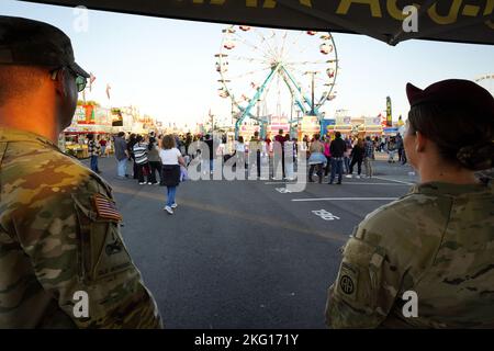 Soldaten sehen zu, wie Fair Goers ihren Abend auf der South Carolina State Fair am Freitag genießen. Wir möchten uns bei allen bedanken, die an unseren letzten Tagen auf der South Carolina State Fair Zeit mit uns verbracht haben, als die Sonne unterging! Hoffentlich haben alle ein wenig mehr über unser Armeeteam einschließlich des Armeereservats und alle Möglichkeiten, die wir zu bieten haben, erfahren. Wir haben es genossen, mit unserer Gemeinde in South Carolina eine Kameradschaft aufzubauen! Foto der US-Armee von Staff Sgt. Crystal Harlow Stockfoto