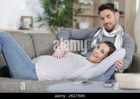 Das Paar freut sich, dass sich sein Baby im Bauch der Ladys bewegt Stockfoto