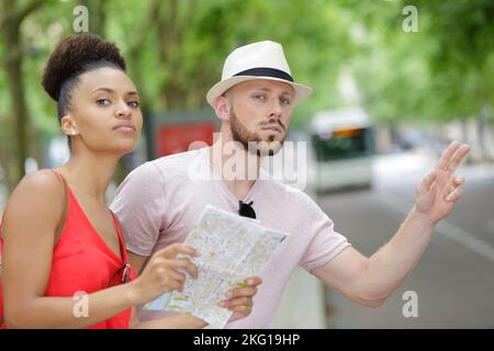 Paar auf Städtereise gestikuliert für einen Bus zu stoppen Stockfoto