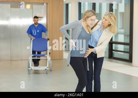 Mutter hilft Tochter, die im Krankenhaus arbeitet Stockfoto
