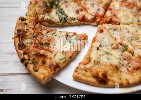 Pizza in Scheiben mit blauem Käse auf einem weißen Teller. Stücke frisch gekochte Pizza. Stockfoto