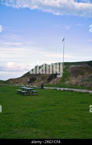 Hundested, Dänemark Picknickplatz vor den Klippen. Fahnenmast mit dänischer Flagge auf dem Hügel. Landschaftsfoto aus Skandinavien Stockfoto