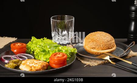 Brötchen und Burger auf einem dunklen Tisch Stockfoto