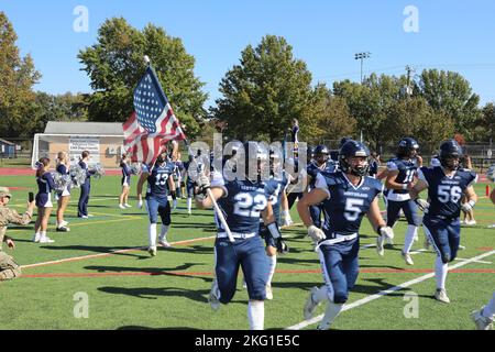 Die Buccaneers der Kent Island High School laufen am 22. Oktober 2022 zum Heimspiel gegen die James M. Bennett High School im KIHS in Stevensville, Maryland, auf den Fußball. Die MDARNG 29. Combat Aviation Brigade zeigte auch einen UH-60 Black Hawk Hubschrauber während des Spiels. Stockfoto