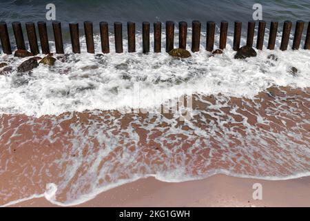 Uferwasser und hölzerne Wellenbrecherstruktur, Ostseeküste an einem sonnigen Sommertag. Swetlogorsk, Oblast Königsberg, Russland Stockfoto