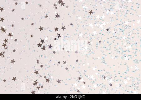 Schimmernde Sterne und blaue Kristalle Konfetti auf silbernem Hintergrund. Glänzende Textur. Stockfoto