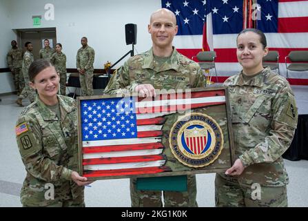 Erstes Sgt. Leesa Petty, scheidender erster Sergeant und Sgt. 1. Class Marina Carrillo, Senior Human Resources non-Commissioned Officer, Headquarters and Headquarters Detachment, 75. Innovation Command, übergibt dem scheidenden HHD-Kommandanten Maj. Christopher Allen eine benutzerdefinierte Plakette als Zeichen der Wertschätzung des Kommandos für Allens dreijährige Amtszeit. Die Holzfahne wurde von Col. Steven Waldrop, dem G3/5/7-Chef des Innovation Command von 75., von Hand gebaut. Stockfoto