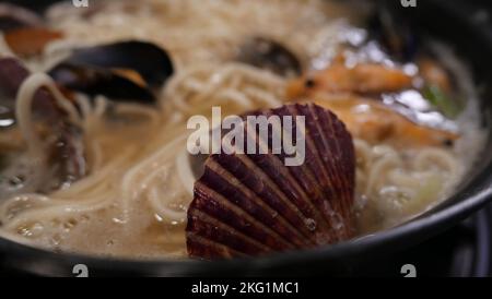 Meeresfrüchte-Eintopf mit Schalentieren und Garnelen in einer Metallpfanne oder einem Topf Stockfoto