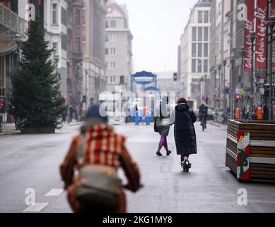 Berlin, Deutschland. 21.. November 2022. Fußgänger, Radfahrer und Scooter-Fahrer sind auf der Friedrichstraße in Berlin-Mitte unterwegs. Die Straße ist immer noch für den Autoverkehr gesperrt, aber die meisten Markierungen wurden bereits entfernt. Auf einem Abschnitt, der seit mehr als zwei Jahren autofrei ist, wird sich der Verkehr bald wieder bewegen. Das Verwaltungsgericht hatte die fortgesetzte Schließung einer rund 500 Meter langen Strecke der Friedrichstraße für illegal erklärt. Quelle: Bernd von Jutrczenka/dpa/Alamy Live News Stockfoto