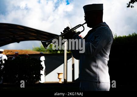 Ein US-Navy-Bugler, der Navy Region Hawaii zugewiesen wurde, spielt Taps, während Matrosen und die Defence POW/MIA Accounting Agency (DPAA) eine Internierung für US-Navy Fireman Second Class Richard E. Casto auf dem National Memorial Cemetery of the Pacific, Honolulu, Hawaii, 24. Oktober 2022, durchführen. Casto wurde der USS Oklahoma zugewiesen, die durch das Feuer japanischer Flugzeuge und mehrere Torpedo-Schläge das Schiff zum Kentern brachte und am 7. Dezember 1941 auf Ford Island, Pearl Harbor, zum Tod von mehr als 400 Besatzungsmitgliedern führte. Die Mission der DPAA ist es, eine möglichst umfassende Abrechnung für fehlende und zu erreichen Stockfoto