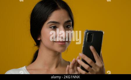 Nahaufnahme Porträt im Studio Indische ethnische 20s Frau Mädchen weibliche Dame Blick auf Smartphone-Bildschirm durchsuchen Eingabe Scrolling Chat Suche im Internet Stockfoto