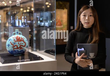 Hongkong, China: 21. November 2022. Bonhams Verkauf chinesischer Keramik und Kunstwerke Gigi Yu, Bonhams Leiter chinesischer Keramik und Kunstwerke, zeigt die Liddell Moonflask. Einer von nur drei bekannten, noch erhaltenen türkisfarbenen Unterglasur-blauen und kupferroten ‘Dragon' Qianlong (vierter Qing-Kaiser, der von 1735 bis 1796 über China regierte) Mondkolben tritt nach einem Jahrzehnt auf den Markt. Die außergewöhnlich seltene Liddell Moonflask aus der angesehenen Huaihaitang Collection（懷海堂）aus Hongkong trägt eine Schätzung von 18.000.000 HK-25.000.000 Alamy Live News/Jayne Russell Stockfoto