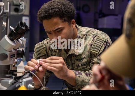 221024-N-IV962-1016 SAN DIEGO (OKT 24, 2022) – Aviation Electronics Technician 3. Class Kendrick Oliver testet die Frequenz in einem Kabel eines computerautomatisierten Unterstützungssystems (CASS) an Bord des amphibischen Angriffsschiffs USS Makin Island (LHD 8), Oktober 24. CASS-Kabel werden zum Testen und Prüfen von MV-22s vor einem Flug verwendet. Makin Island ist ein amphibisches Angriffsschiff der Wasp-Klasse, das in San Diego homeportiert wurde. Stockfoto