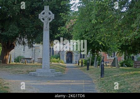 Kriegsdenkmal und alte Grabsteine in einem ländlichen Kirchhof mit alten Bäumen, Kirschen und Eibenbäumen im frühen Morgenlicht. Kintbury, St. Mary's Church, in der Nähe von Hung Stockfoto