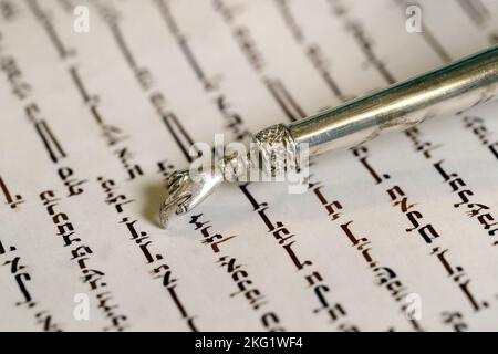 Nahaufnahme des traditionellen Torah-Buchs und des yad in der Synagoge. Tora-Lesung. Stockfoto