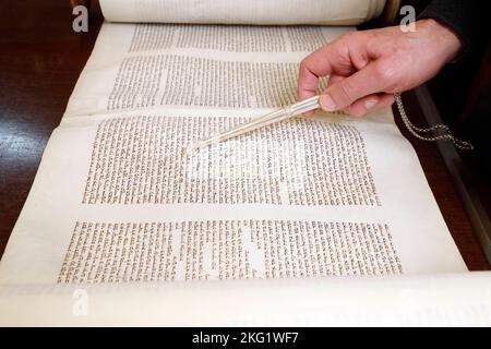 Rabbin hält einen yad in der Hand und liest eine uralte Tora-Schriftrolle. Yom Kippur. Stockfoto