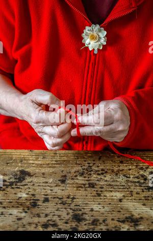 Buddhistische Nonne bindet Faden in Westfrankreich Stockfoto