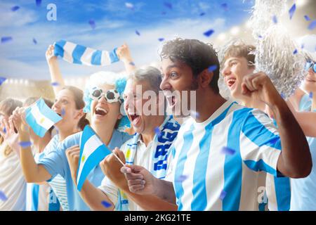 Argentinischer Fußballfan im Stadion. Argentinische Fans auf dem Fußballplatz beobachten das Mannschaftsspiel. Eine Gruppe von Unterstützern mit Flagge und Nationaltrikot Stockfoto