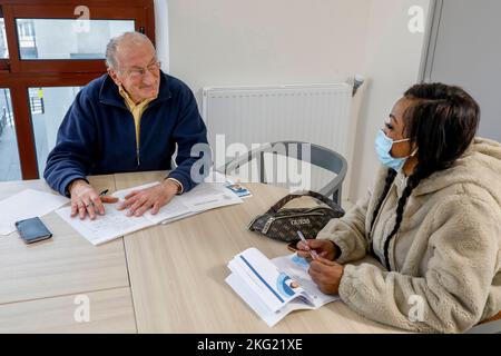 Volunteer hilft einer Migrantin bei ihrer Jobsuche bei La Maison Bakhita, Paris, Frankreich Stockfoto