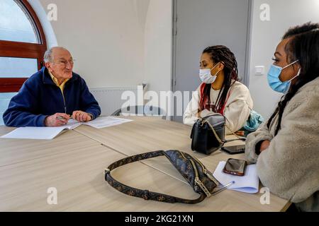 Volunteer hilft einer Migrantin bei ihrer Jobsuche bei La Maison Bakhita, Paris, Frankreich Stockfoto