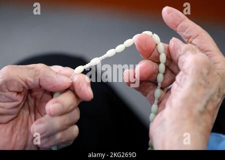 Dominikanerin zahlt die Rosenkranz Perlen. Nahaufnahme der Hände. Katholische Kirche. Bien Hoa. Vietnam. Stockfoto